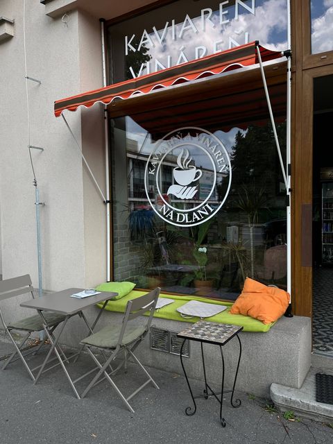 Výklad s logom Na dlani a lavičkou s farebnými vankúšmi