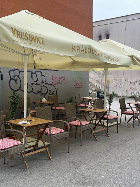 Slnečníky nad stolíkmi na terase kaviarničky na Hlinkovej